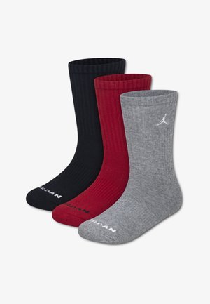 Tre paia di calzini in cotone a costine nei colori nero, rosso e grigio. Caratteristiche includono una suola imbottita e un logo bianco vicino al polsino.