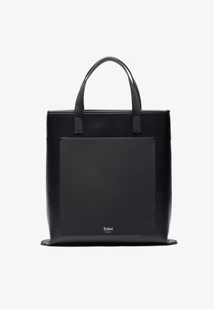 Svart totebag med glatt lærtekstur, rektangulær form, to håndtak og en frontpanel. Har et logo nederst.