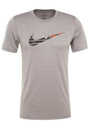 T-shirt à manches courtes Nike Dri-FIT gris clair avec un grand logo Nike Swoosh noir et orange centré sur la poitrine.