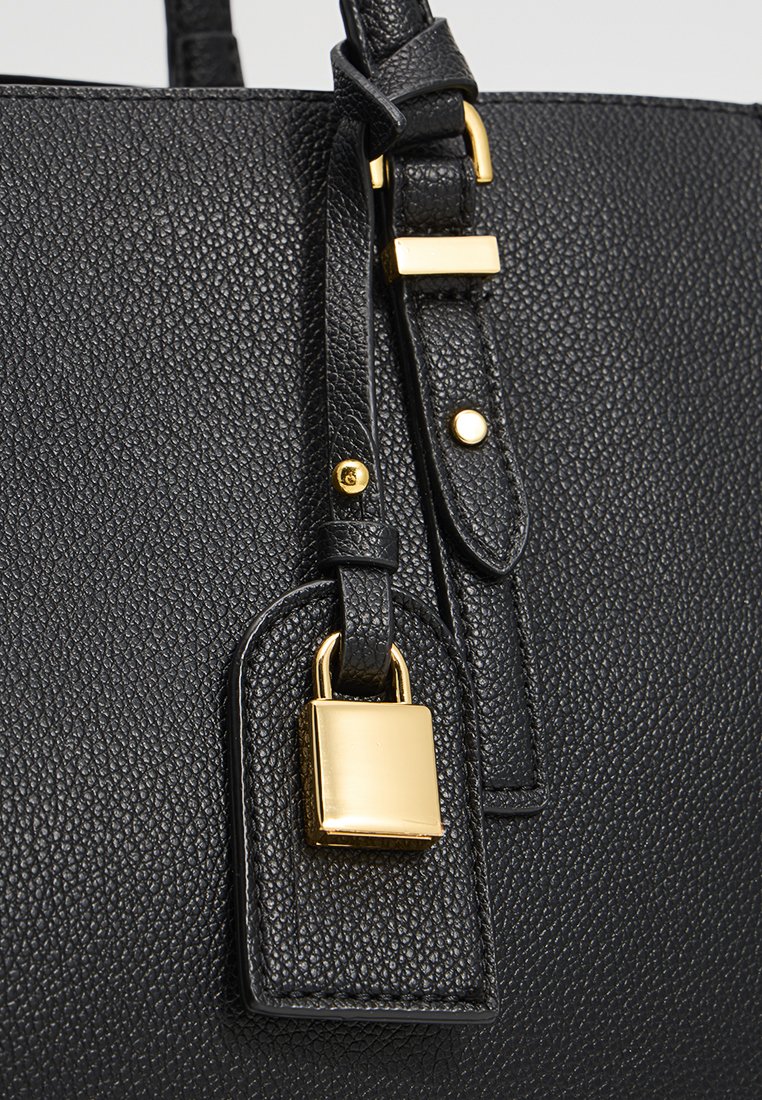 Borsa a tracolla in pelle nera con finiture in oro, inclusi un lucchetto e dettagli sulla tracolla. Caratterizzata da un design strutturato e da cuciture dettagliate.