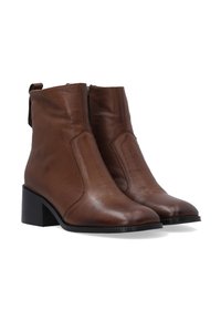 Hnědé kožené kotníkové boty s block podpatky, kulatou špičkou a bočním zipem, zobrazené v páru na bílém pozadí.