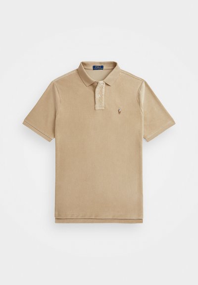 Beżowa koszulka polo z fakturowanej tkaniny, z kołnierzykiem, zapięciem na dwa guziki oraz małym haftowanym logo na piersi.