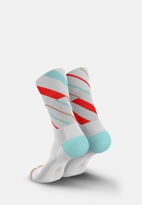 Weiße Socken mit auffälligen diagonalen Streifen in Rot, Türkis und Beige, einer strukturierten Oberfläche und soliden türkisfarbenen Akzenten an den Bündchen.