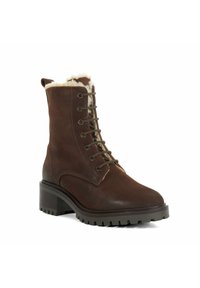Bruin leren enkelboot met een faux fur voering, veter sluiting aan de voorkant en een gestructureerde rubberen buitenzool, met een blokhak voor stabiliteit.