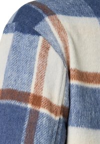 Flanellhemd mit einem Karo-Muster in Blau, Weiß und Beige. Weiche Textur, abgerundete Schultern, mit einem markanten Karodesign.