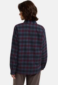 Camicia a maniche lunghe a quadri in bordeaux e blu navy, con colletto e vestibilità morbida, caratterizzata da un motivo a griglia e polsini con bottoni.