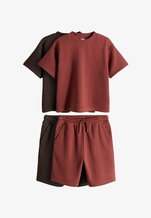 Dwa zestawy casualowe z krótkimi rękawami i bluzkami z okrągłym dekoltem oraz szortami z wiązaniem w talii, jeden w kolorze rdzawoczerwonym, drugi w ciemnobrązowym, ułożone płasko na białym tle.