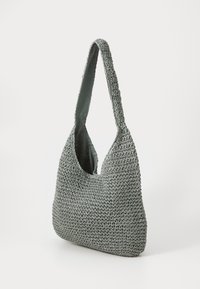Sac à épaule tissé gris avec une forme incurvée, présentant un extérieur texturé et une doublure intérieure lisse. Bandoulière réglable pour un transport facile.