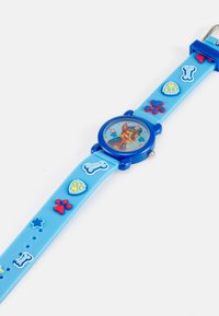 Relógio azul de silicone com um personagem de desenho animado no mostrador, apresentando impressões de patas texturizadas, ossos e estrelas na bracelete em várias cores.