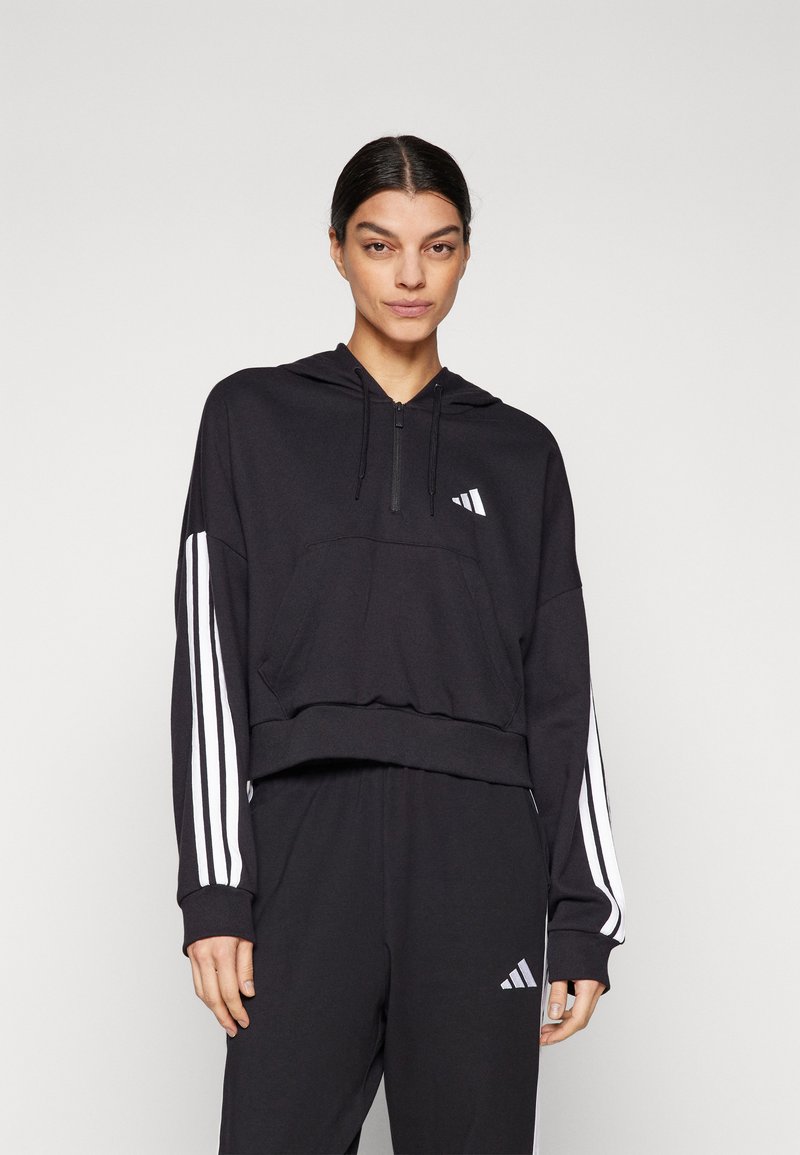 Črna kapuca s krvavo zadrgo, vsebuje belo Adidas logo in tri bele črtice na rokavih. Narejena iz mehke tkanine z ohlapnim krojem.