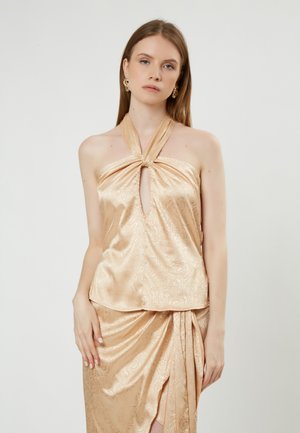 Top in satin color beige con apertura a chiave, dettaglio a nodo sul collo e un motivo a rosa texture. Attaccato a una gonna coordinata.