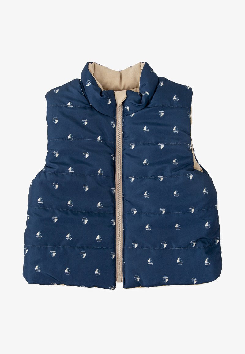 Chaleco acolchado de color azul marino con cremallera en la parte delantera, que presenta pequeños patrones de barcos. El interior tiene un forro color crema, con un cuello alto y textura acolchada.