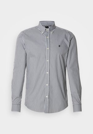 Prugasta košulja dugih rukava u mornarsko plavoj i bijeloj boji, s ovratnikom na kopčanje, prednjim zatvaranjem na gumbe i detaljem s logotipom na prsima.