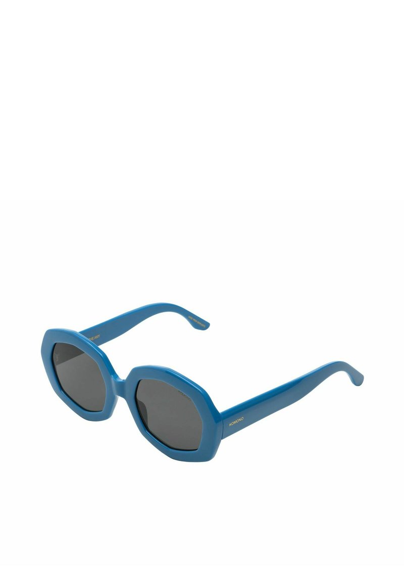 Lunettes de soleil bleues en forme d'octogone avec des verres sombres. La monture en plastique présente une texture lisse et des branches élégantes avec un détail de marque doré.
