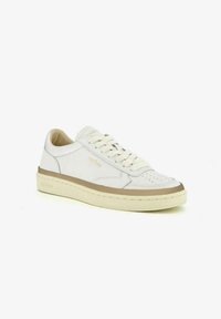 Sneaker in pelle bianca con dettagli perforati, accenti beige sui lati e sulla suola, e una suola in gomma cremoso texturizzata. I lacci sono di colore crema.