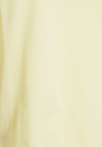 Lichtgele stof, zachte textuur, glad oppervlak, met subtiele tintvariaties, kenmerkend voor katoenmateriaal.