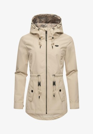 Giacca impermeabile beige con cappuccio, vita regolabile con cordino, due tasche anteriori e foderatura con motivo floreale. Presenta una chiusura con zip e dettagli a contrasto.