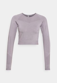 Dlouhý crop top s dlouhým rukávem ve světle levandulové látce s texturovanými, větranými panely a žebrovanými akcenty podél ramen a rukávů.