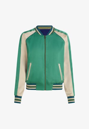 Zielona kurtka typu bomber z kremowymi rękawami, ściągaczem przy kołnierzu i mankietach. Posiada boczne kieszenie z detalami w kształcie strzałek oraz zapinana jest na zamek z przodu.