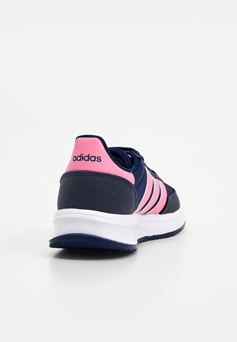 Baskets de sport bleu marine avec un talon rose, trois bandes roses sur le côté et une semelle blanche. Fabriquées en textile et en daim.