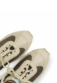 Sneakers in pelle e camoscio beige e verde oliva, caratterizzate da una punta affusolata, design con lacci e accenti di cucitura blu a contrasto.