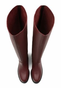 Burgundy knee-high boots with a textured leather exterior, rounded toe, and a smooth inner lining. Zippered back for easy wear.