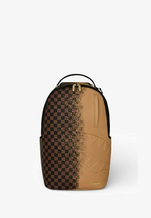 Zaino con motivo a scacchiera nero e marrone sul lato sinistro, tinta unita color sabbia sul lato destro con design di denti di squalo in rilievo e tiretti delle zip dorati.