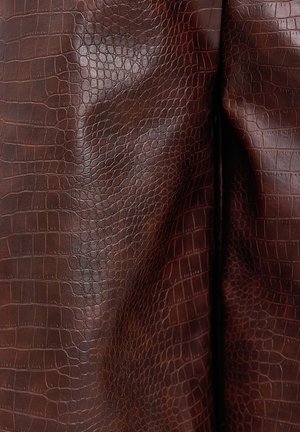 Cuir synthétique marron texturé avec un motif peau de crocodile, présentant un éclat subtil et des plis doux, créant une apparence tactile riche.