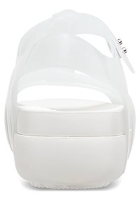 Vit transparent sandal med tjock sula, med en slät finish, minimalistisk design och dubbla metalliska accentdetaljer på remmen.