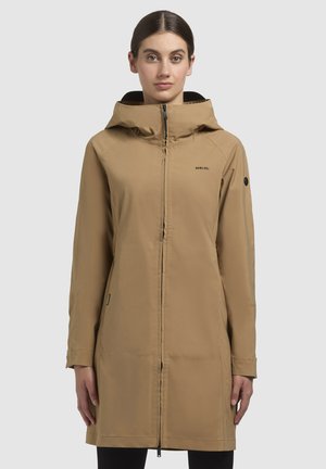 Parka imperméable beige avec capuche, fermeture éclair et poches latérales. Présente un design épuré et une texture lisse, adaptée à une utilisation en extérieur.