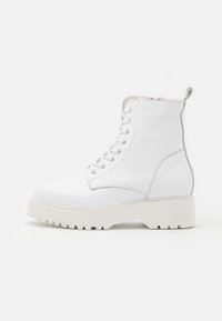 Bottes en cuir blanc avec une finition texturée, hauteur de cheville, design à lacets, semelle en caoutchouc et accents métalliques à l'arrière.