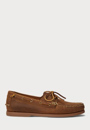Scarpa da barca in pelle marrone con design a profilo basso, dotata di occhielli in ottone, cuciture decorative e chiusura con lacci. Suola piatta in gomma.