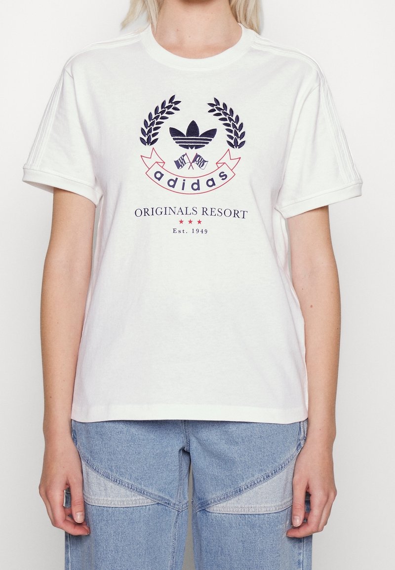 Witte katoenen T-shirt met een marineblauw en rood gedrukt logo met lauweraccenten en de tekst "adidas ORIGINALS RESORT Est. 1949."