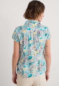 Cămașă cu guler, cu mâneci scurte, cu un model abstract multicolor. Materialul pare ușor, cu o croială lejeră și o margine curbată.
