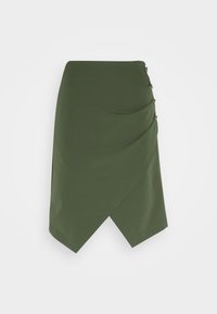 Jupe vert foncé longueur genou avec ourlet asymétrique et tissu décoratif superposé en diagonale fixé par quatre boutons sur un côté.