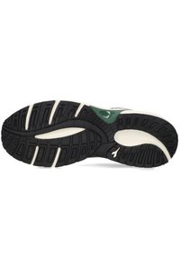 Suola di sneaker nera in gomma con intersuola bianca, dotata di un motivo di battistrada testurizzato e un accento verde vicino al tallone.