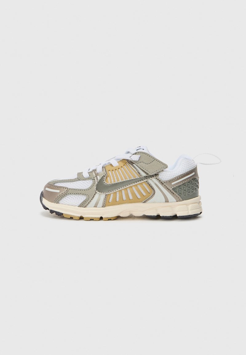 Sport Schuh mit einem Obermaterial aus Netz und Synthetik in Olivgrün, mit weißen und goldenen Akzenten. Verfügt über ein strukturiertes Muster an der Ferse, flachen Schnürsenkeln und einer gepolsterten Sohle.