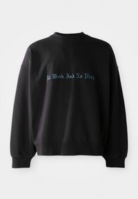 Felpa nera in cotone, con collo a giro e spalle cadenti. Sul davanti è stampata la frase "Tanto lavoro e niente gioco" in testo blu.