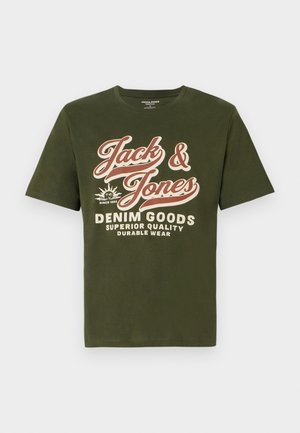 Olivinės spalvos medvilnės marškinėliai trumpomis rankovėmis ir apvalia iškirpte. Priekyje yra didelis baltas ir raudonas tekstas: "Jack & Jones Denim Goods."
