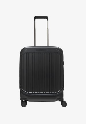 Valigia nera rigida con texture a costine verticali, due ruote lisce e manico retrattile sulla parte superiore.