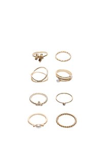 Set von neun goldenen Ringen mit verschiedenen Designs: gewunden, mit Perlenakzenten, mit floralen Details und einfachen Bändern mit dekorativen Elementen.