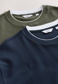 Two striped crew neck T-shirts in dark green and navy blue. Each has a white collar and ribbed texture. Labels visible on the inside.