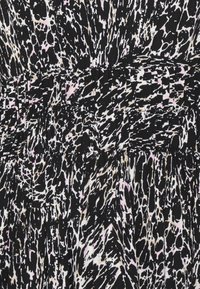 O tecido do vestido preto apresenta um padrão abstrato arrojado com acentos em branco e rosa claro, texturizado com secções franzidas para um design fluido.