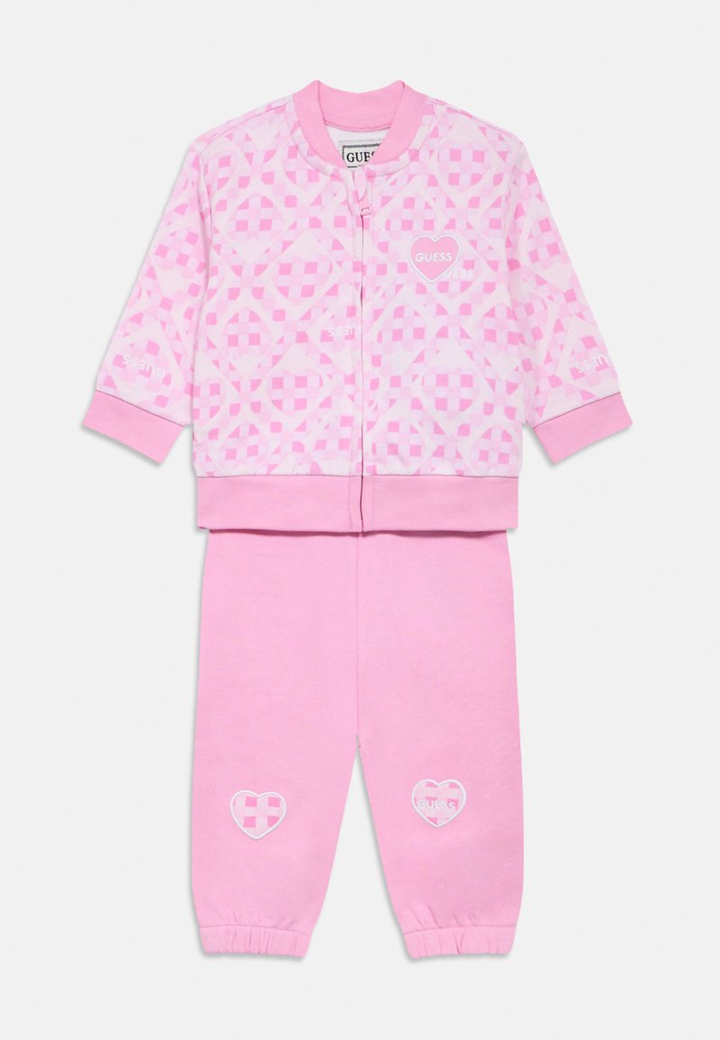 Tuta di cotone rosa composta da giacca con zip e motivo a scacchi con dettagli ricamati a forma di cuore, abbinata a pantaloni coordinati.
