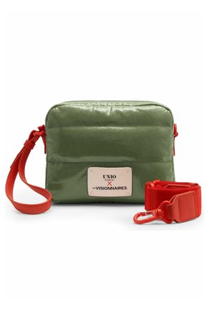 Petit sac rectangulaire vert olive avec étiquette avant et bandoulière large rouge amovible avec boucle métallique sur fond blanc.