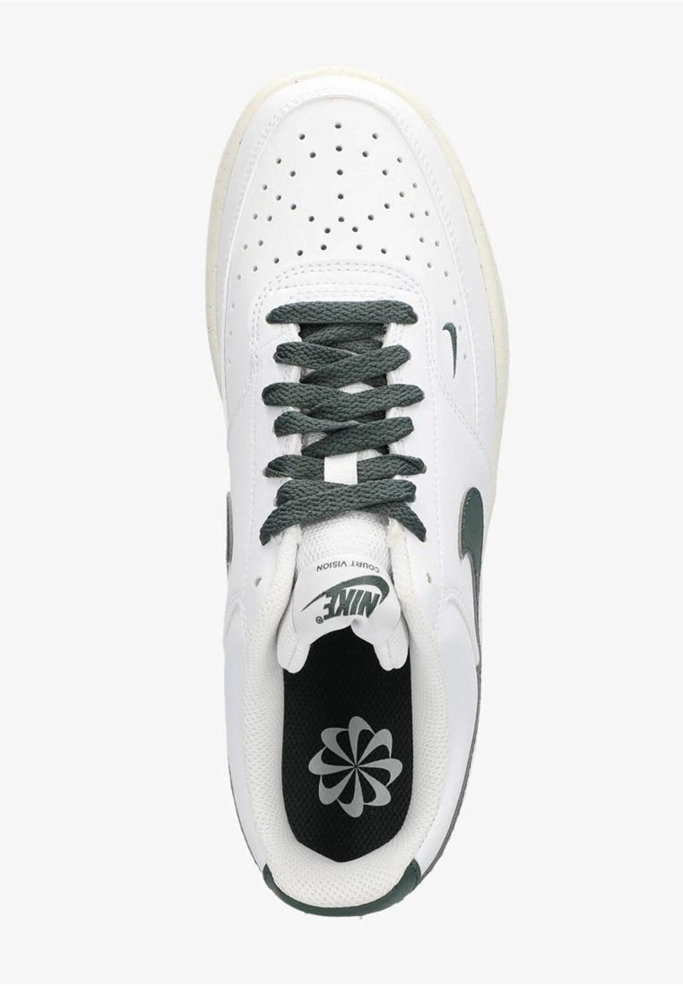 Sneaker bianco con accenti verdi, tomaia in pelle testurizzata, punta perforata e lacci piatti. Include un logo sulla linguetta e una soletta ammortizzata.