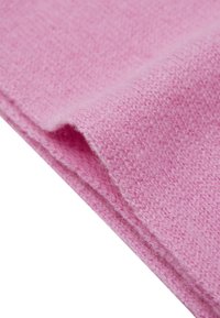 Tessuto lavorato a maglia di un rosa chiaro, texture morbida, dettagli del tessuto visibili, con un bordo leggermente ripiegato che espone le fibre interne.