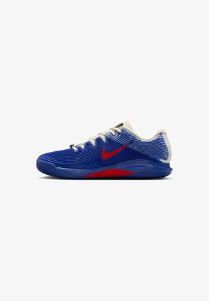 Blaue und weiße Sportschuhe mit vertikal gerippter Textur, roten Akzenten, schwarzen Schnürsenkeln und einer flexiblen Sohle, die für Bewegung und Grip ausgelegt ist.