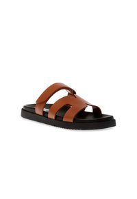 Bruine leren sandalen met twee brede banden, open tezijde ontwerp en een zwarte rubberen zool. De banden hebben een minimalistisch uitsnede stijl.