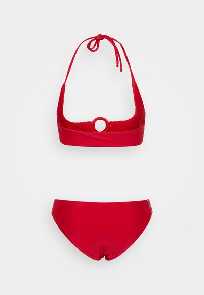Röd bikini-set med halterneck topp som har en cirkulär detalj och matchande lågt skuren botten, båda i mjukt och elastiskt tyg.